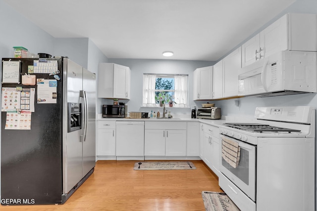 3310 Moonlight Ave, El Paso, TX 79904 - kitchen with appliances with stainless steel finishes, white cabinetry, light countertops, and light wood finished floors
