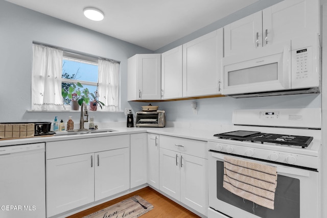 3310 Moonlight Ave, El Paso, TX 79904 - kitchen with white appliances, light countertops, white cabinets, and light wood-style floors