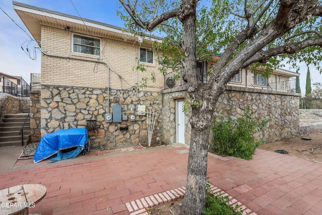 3310 Moonlight Ave, El Paso, TX 79904 - rear view of property with stone siding, stairs, a patio, and brick siding