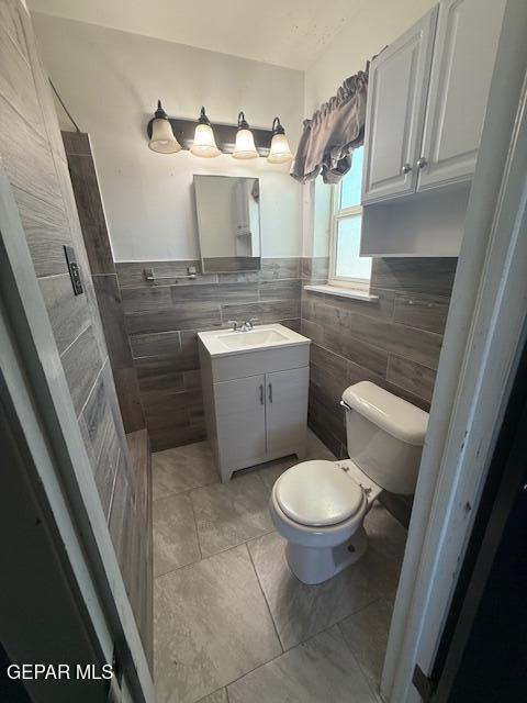 8141 Callison Rd, El Paso, TX 79907 - bathroom with tile walls, vanity, tile patterned flooring, and a wainscoted wall