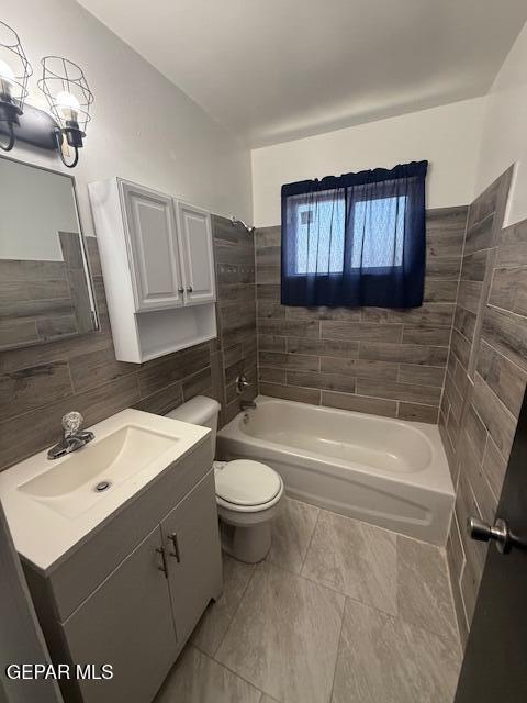 8141 Callison Rd, El Paso, TX 79907 - full bathroom featuring a bath, tile walls, vanity, and tile patterned flooring