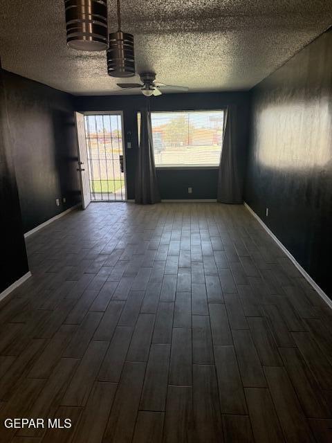 8141 Callison Rd, El Paso, TX 79907 - unfurnished room with a textured ceiling, a ceiling fan, plenty of natural light, and dark wood-style flooring