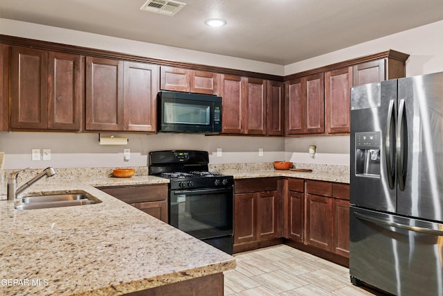 11625 Flor Clavel St, El Paso, TX 79927 - kitchen with black appliances, light stone counters, recessed lighting, and dark brown cabinetry