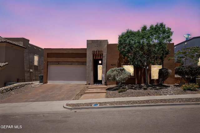 6585 Hermoso Del Sol Dr, El Paso, TX 79911 - pueblo revival-style home featuring driveway, a garage, and stucco siding