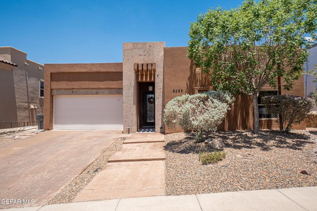 6585 Hermoso Del Sol Dr, El Paso, TX 79911 - adobe home with concrete driveway, stucco siding, and an attached garage