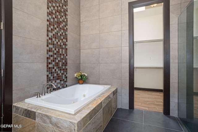 6585 Hermoso Del Sol Dr, El Paso, TX 79911 - bathroom with a whirlpool tub, tile walls, and tile patterned flooring