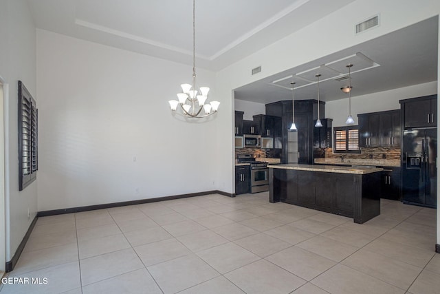 6585 Hermoso Del Sol Dr, El Paso, TX 79911 - kitchen with stainless steel appliances, tasteful backsplash, light tile patterned flooring, a kitchen island, and a chandelier