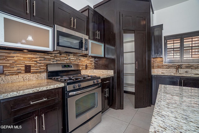 6585 Hermoso Del Sol Dr, El Paso, TX 79911 - kitchen with appliances with stainless steel finishes, light stone counters, light tile patterned floors, and tasteful backsplash