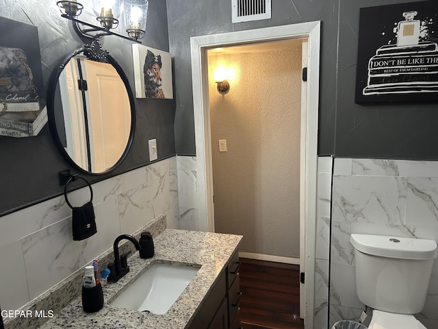 1012 Maple St, El Paso, TX 79903 - bathroom featuring tile walls, vanity, wood finished floors, and a chandelier