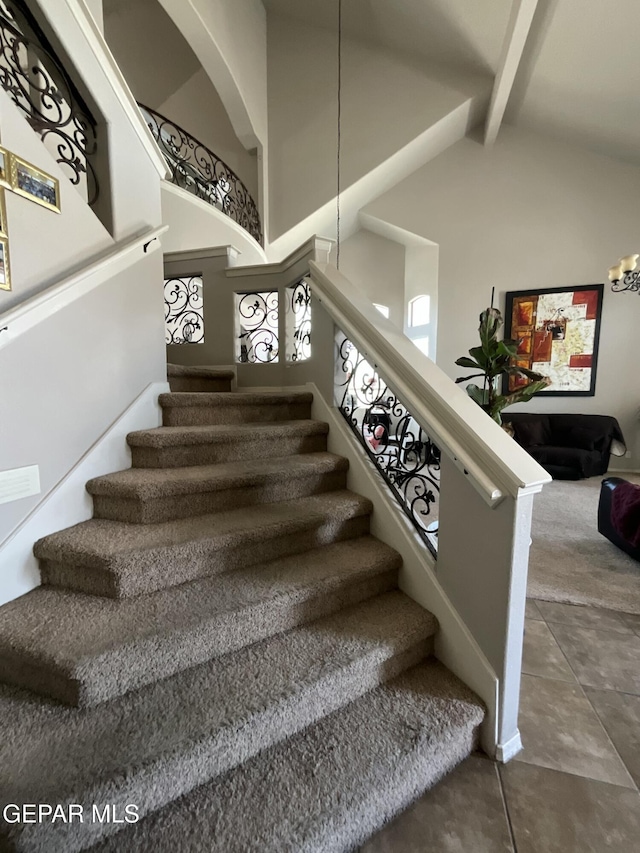 12000 Stansbury Dr, El Paso, TX 79928 - staircase with beam ceiling, high vaulted ceiling, and a chandelier