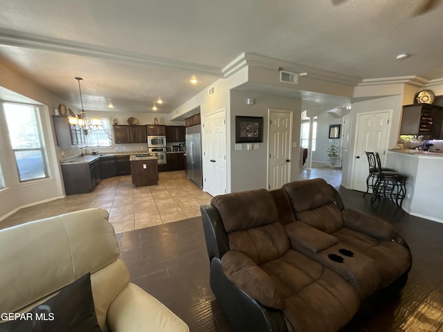 12000 Stansbury Dr, El Paso, TX 79928 - living area with arched walkways, a chandelier, plenty of natural light, crown molding, and light tile patterned floors