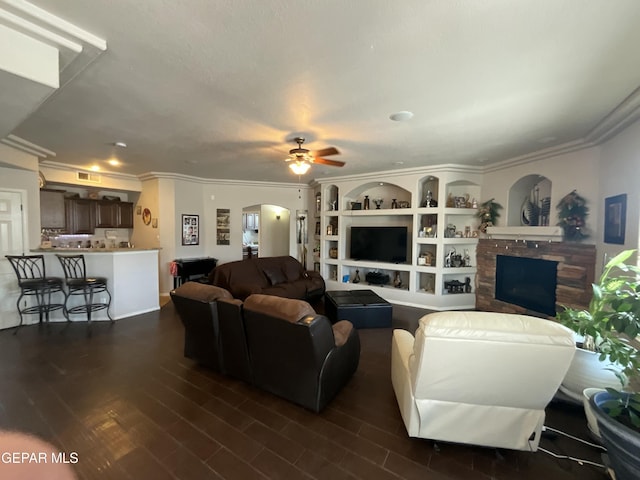 12000 Stansbury Dr, El Paso, TX 79928 - living area featuring a ceiling fan, arched walkways, ornamental molding, dark wood finished floors, and a stone fireplace