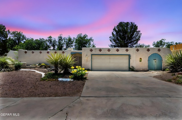 5536 Fernwood Cir, El Paso, TX 79932 - pueblo revival-style home with stucco siding, a garage, and concrete driveway