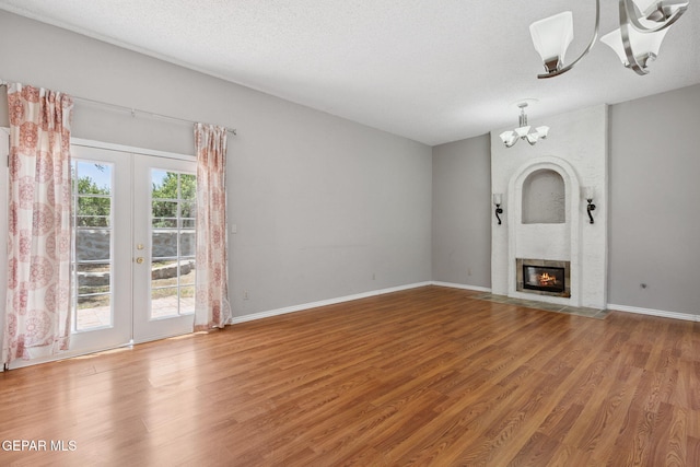 5536 Fernwood Cir, El Paso, TX 79932 - unfurnished living room with a chandelier, french doors, wood finished floors, and a fireplace