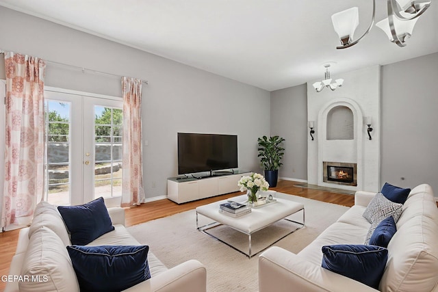 5536 Fernwood Cir, El Paso, TX 79932 - living room featuring a chandelier, wood finished floors, french doors, and a fireplace