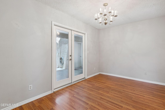 5536 Fernwood Cir, El Paso, TX 79932 - spare room with a chandelier, french doors, wood finished floors, and a textured ceiling