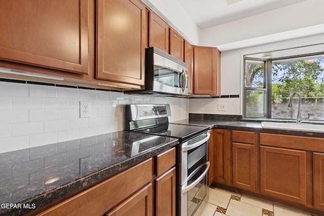 5536 Fernwood Cir, El Paso, TX 79932 - kitchen featuring stainless steel appliances, tasteful backsplash, brown cabinetry, and dark stone countertops