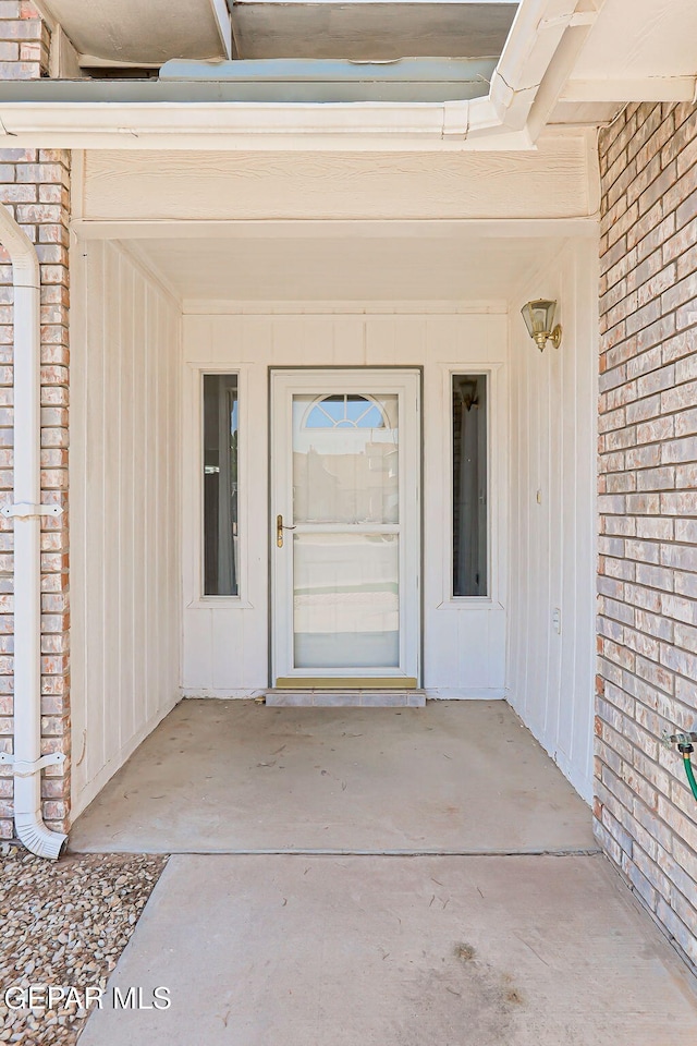 11948 Crown Oaks Ct, El Paso, TX 79936 - view of exterior entry featuring a patio, board and batten siding, and brick siding