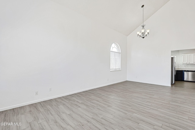 11948 Crown Oaks Ct, El Paso, TX 79936 - unfurnished living room featuring high vaulted ceiling, a chandelier, and light wood-style floors