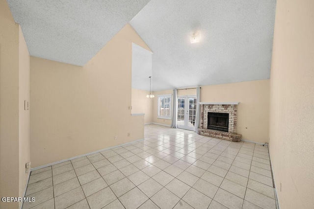 11984 Manuel Acosta Dr, El Paso, TX 79936 - unfurnished living room featuring a textured ceiling, a brick fireplace, light tile patterned floors, and lofted ceiling