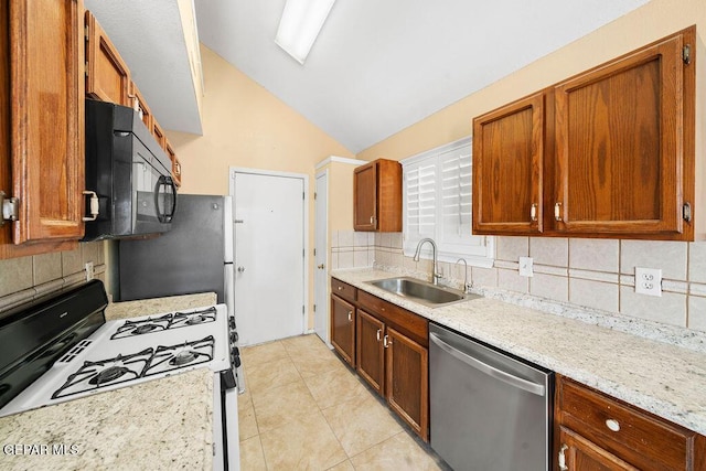 11984 Manuel Acosta Dr, El Paso, TX 79936 - kitchen with dishwasher, white range with gas cooktop, black microwave, lofted ceiling, and tasteful backsplash