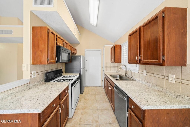 11984 Manuel Acosta Dr, El Paso, TX 79936 - kitchen with stainless steel appliances, lofted ceiling, backsplash, light tile patterned floors, and brown cabinetry