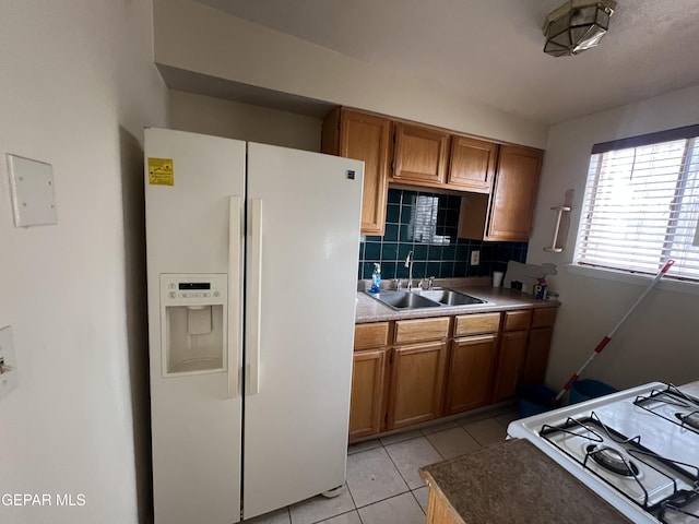 327 Jesuit Dr, El Paso, TX 79907 - kitchen with white appliances, brown cabinets, backsplash, light tile patterned flooring, and light countertops