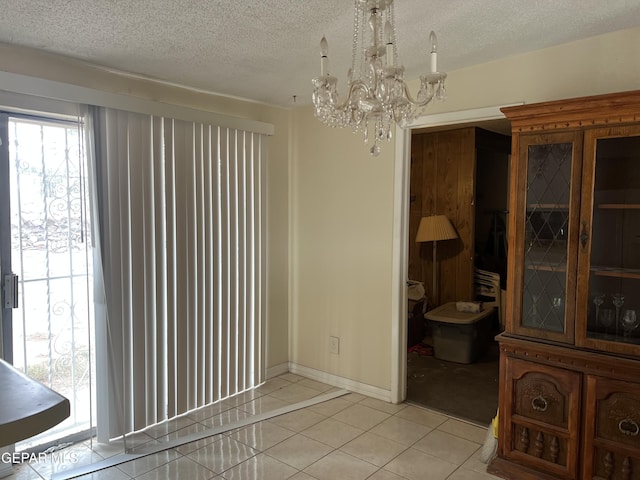 327 Jesuit Dr, El Paso, TX 79907 - unfurnished dining area with a chandelier, a textured ceiling, and light tile patterned floors