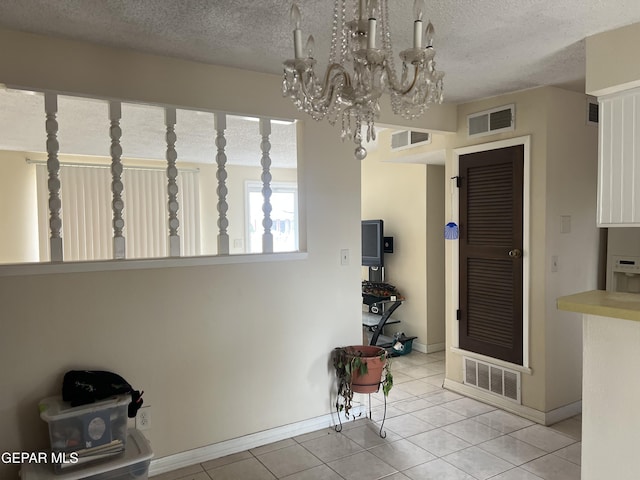 327 Jesuit Dr, El Paso, TX 79907 - dining space with a textured ceiling, light tile patterned floors, and a chandelier