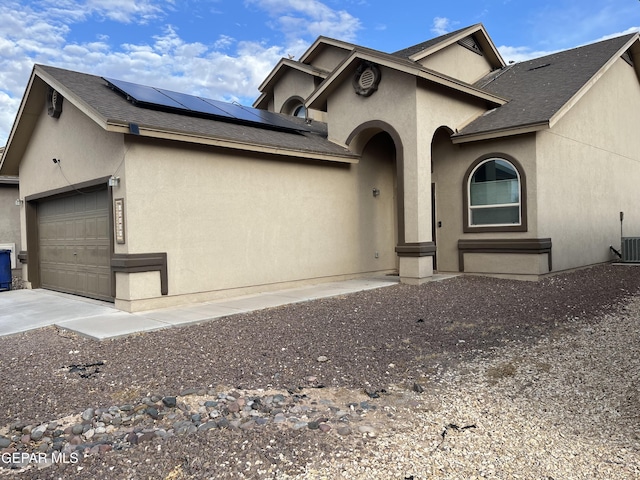 14428 Johnny Mata Dr, El Paso, TX 79938 - view of front of home with an attached garage, stucco siding, solar panels, concrete driveway, and a shingled roof