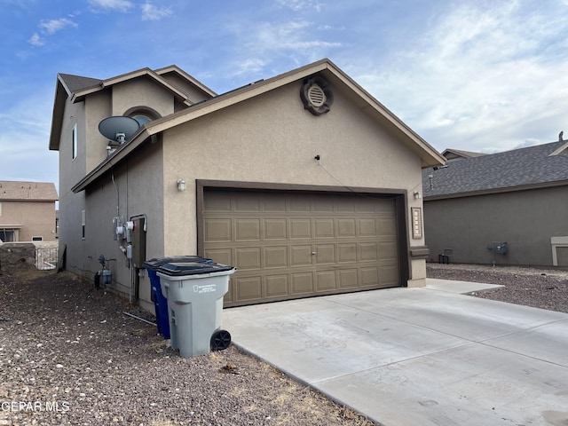 14428 Johnny Mata Dr, El Paso, TX 79938 - view of side of home with a garage, stucco siding, and concrete driveway