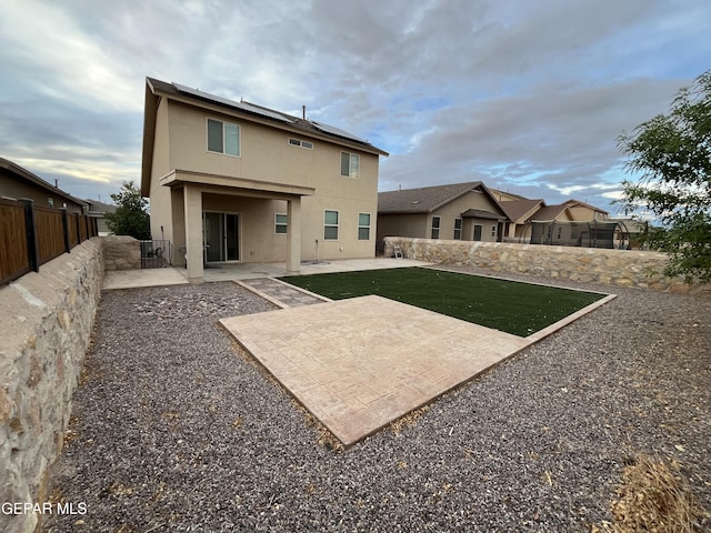 14428 Johnny Mata Dr, El Paso, TX 79938 - back of property featuring stucco siding, a patio area, solar panels, and a fenced backyard