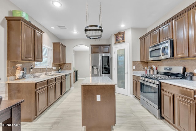 3165 Destiny Point Dr, El Paso, TX 79938 - kitchen with appliances with stainless steel finishes, a center island, arched walkways, backsplash, and recessed lighting