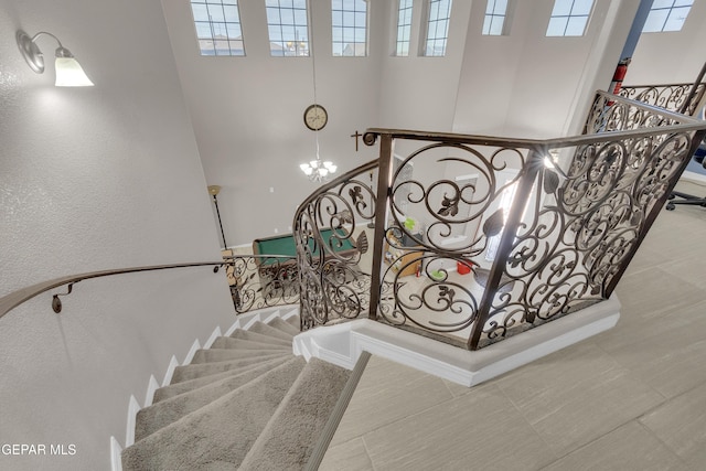3165 Destiny Point Dr, El Paso, TX 79938 - staircase featuring a high ceiling, a chandelier, and a textured wall