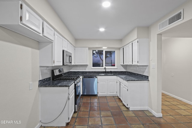 15081 Darrington Rd, Horizon City, TX 79928 - kitchen featuring stainless steel appliances, backsplash, white cabinetry, recessed lighting, and dark tile patterned floors