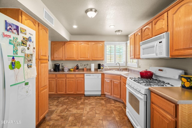18986 Armington Dr, Horizon City, TX 79928 - kitchen featuring white appliances, recessed lighting, a textured ceiling, light countertops, and light stone finish flooring