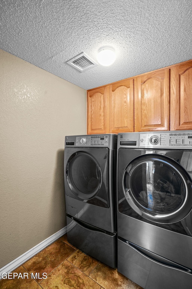 18986 Armington Dr, Horizon City, TX 79928 - washroom featuring cabinet space, separate washer and dryer, and a textured ceiling