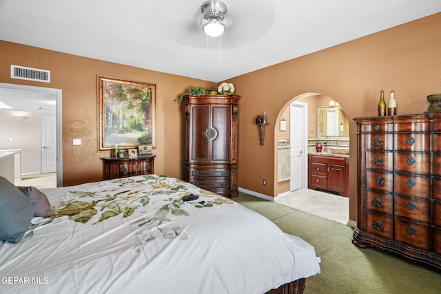 18986 Armington Dr, Horizon City, TX 79928 - bedroom with arched walkways, ensuite bath, light carpet, and a ceiling fan