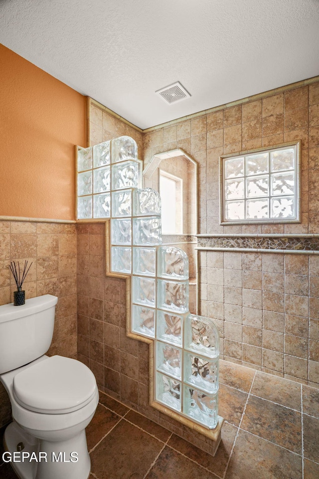 18986 Armington Dr, Horizon City, TX 79928 - bathroom with tile walls and a textured ceiling
