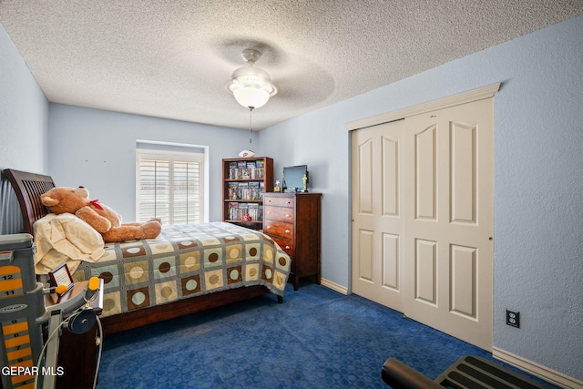 18986 Armington Dr, Horizon City, TX 79928 - bedroom with dark carpet, a closet, a textured ceiling, and ceiling fan
