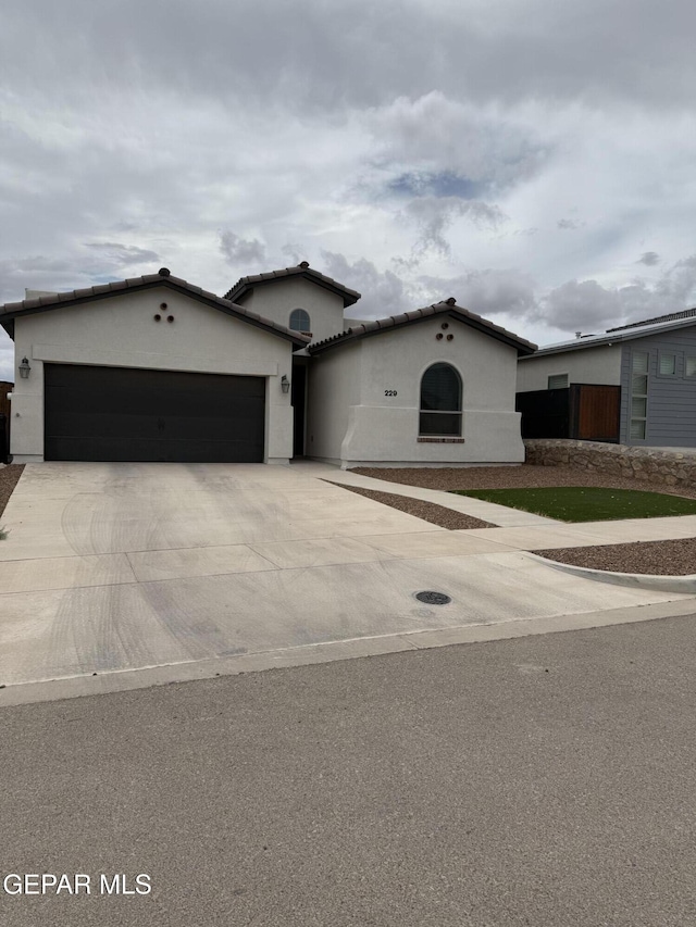 229 Epsom Dr, El Paso, TX 79928 - mediterranean / spanish house featuring a garage, concrete driveway, and stucco siding