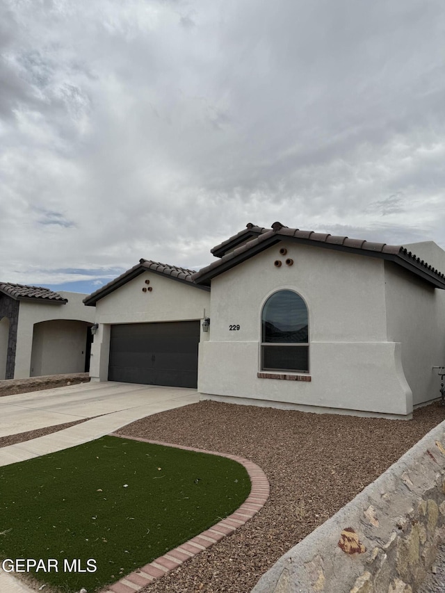 229 Epsom Dr, El Paso, TX 79928 - mediterranean / spanish home with driveway, an attached garage, a tile roof, and stucco siding