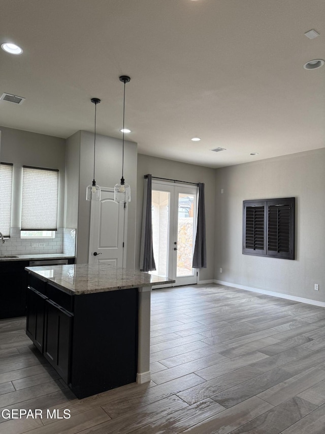 229 Epsom Dr, El Paso, TX 79928 - kitchen featuring dark cabinetry, light wood-style flooring, a center island, recessed lighting, and light stone counters