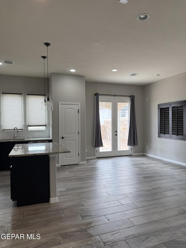 229 Epsom Dr, El Paso, TX 79928 - kitchen featuring a center island, wood tiled floors, light stone counters, tasteful backsplash, and recessed lighting