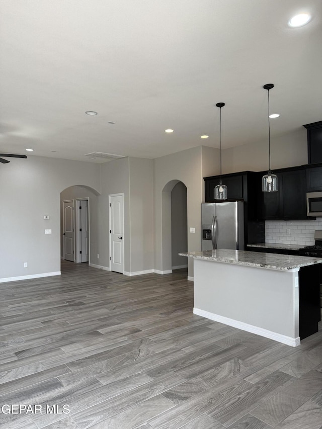 229 Epsom Dr, El Paso, TX 79928 - kitchen featuring appliances with stainless steel finishes, arched walkways, a center island, open floor plan, and recessed lighting