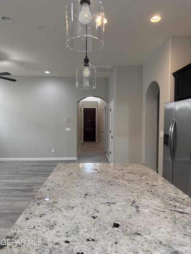 229 Epsom Dr, El Paso, TX 79928 - kitchen with stainless steel refrigerator with ice dispenser, arched walkways, recessed lighting, light stone counters, and light wood-type flooring