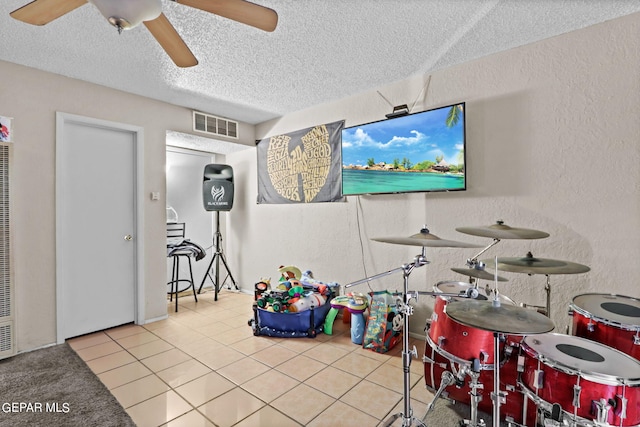 4330 Frankfort Ave, El Paso, TX 79903 - rec room featuring a textured ceiling, a ceiling fan, tile patterned floors, a textured wall, and a heating unit
