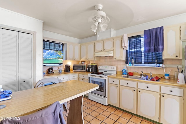 4330 Frankfort Ave, El Paso, TX 79903 - kitchen with white electric stove, under cabinet range hood, stainless steel microwave, ceiling fan, and light tile patterned floors