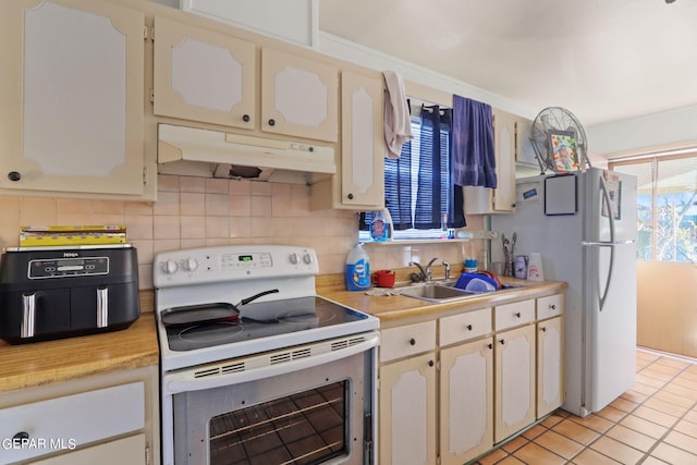4330 Frankfort Ave, El Paso, TX 79903 - kitchen featuring white appliances, under cabinet range hood, light countertops, and decorative backsplash