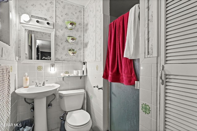 4330 Frankfort Ave, El Paso, TX 79903 - half bathroom with wallpapered walls, wainscoting, and tile walls